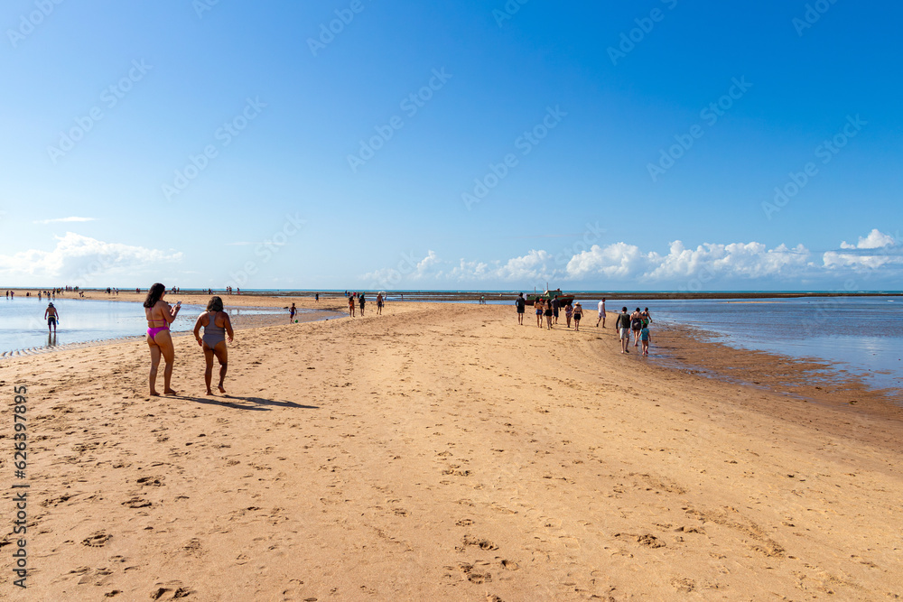 People Walking on the Path of Moses. Phenomenon realized by the meeting of the River with the Sea at Praia de Coroa Vermelha in Porto Seguro, Bahia, Brazil