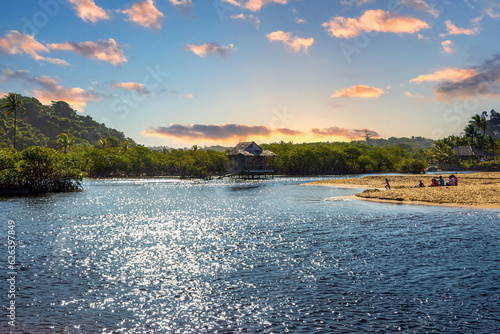 Old fishermen’s house on the river at beautiful sandy beach with palm trees in Trancoso, near Porto Seguro, Bahia, Brazil photo