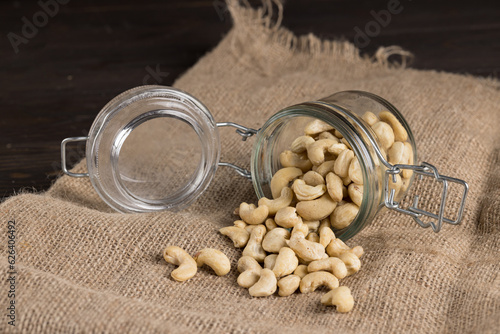 Cashew nuts in a jar with a lid on the table on a bag. Placer. Cashew