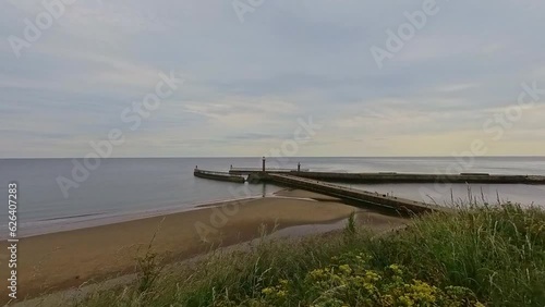 Wallpaper Mural Whitby, North Yorkshire, UK – June 30 2023. View toward the East Pier and beach in the seaside town of Whitby on the North Yorkshire Coast. Captured from the cliff tops above Torontodigital.ca