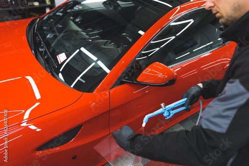 cleaning a red car with washing machine spray at the repair shop. High quality photo © PoppyPix