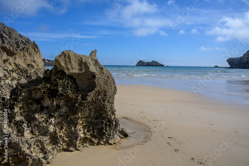 View on Playa de Palombina Las Camaras in Celorio, Green coast of Asturias, North Spain with sandy beaches, cliffs, hidden caves, green fields and mountains. photo