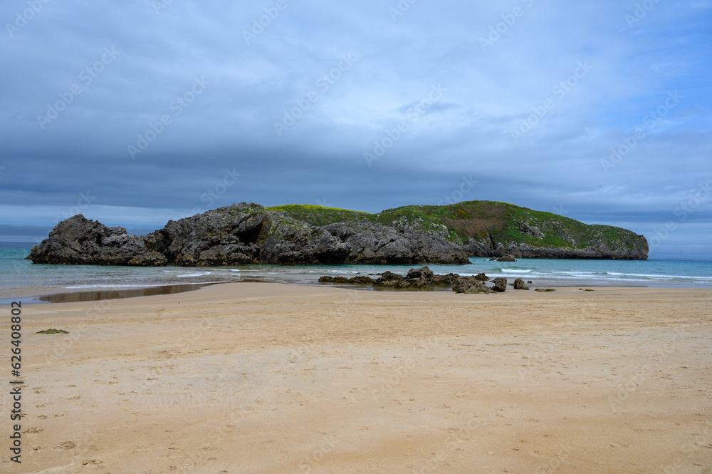View on Playa de Borizo in Celorio, Green coast of Asturias, North Spain with sandy beaches, cliffs, hidden caves, green fields and mountains.