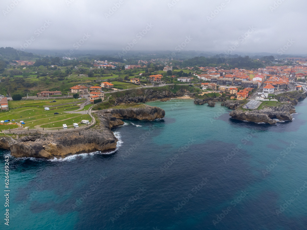 Aerial view on Playa de Toro and Llanes old harbour, Green coast of Asturias, North Spain with sandy beaches, cliffs, hidden caves, green fields and mountains.