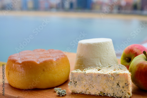 Asturian cheeses, hard smoked cow cheese from Pria, blue cheese cabralis from Arenas and white rebollin from Pitu, Asturias, served outdoor with view on San Lorenzo beach in Gijon photo