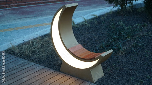 Glowing Crescent Lamp Bench in evening park photo