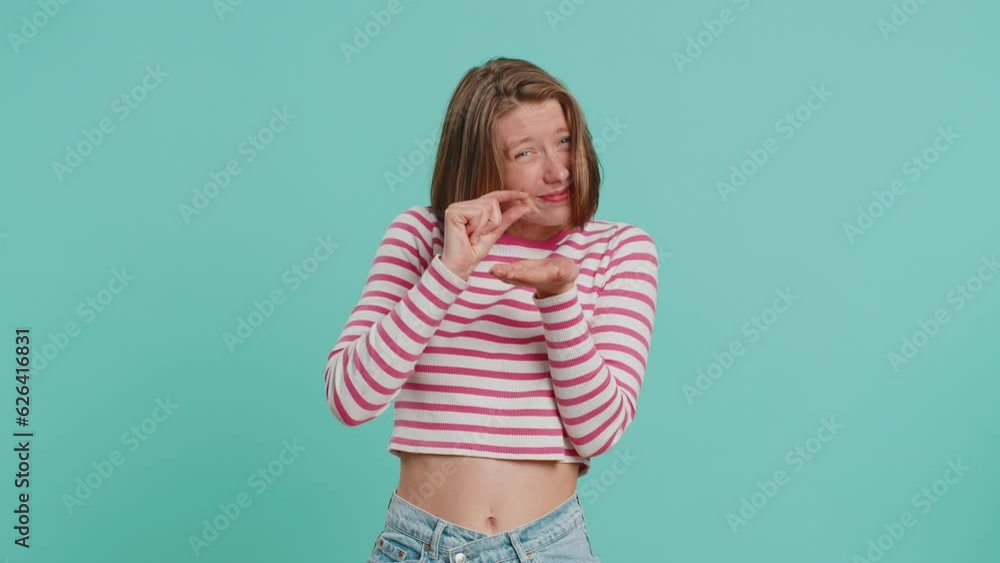 Need some more, please give me, help. Woman showing a little bit gesture with sceptic smile, showing minimum sign measuring small size. Pretty girl in crop top isolated alone on blue studio background Need some more, please give me, help. Woman showing a little bit gesture with sceptic smile, showing minimum sign measuring small size. Pretty girl in crop top isolated alone on blue studio background