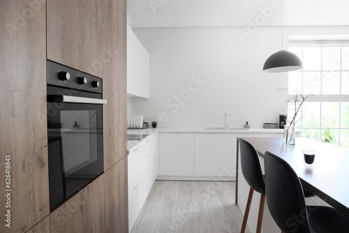 фотографія Wooden furniture with modern built-in oven in kitchen