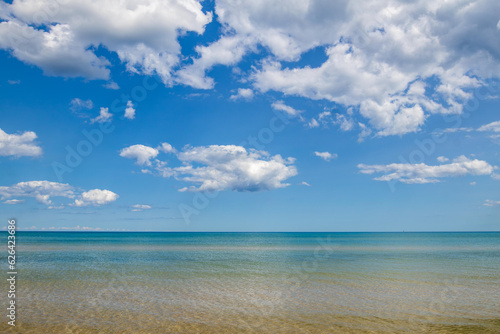 blue sky with white puffy cumulus clouds over Lake Michigan in summer