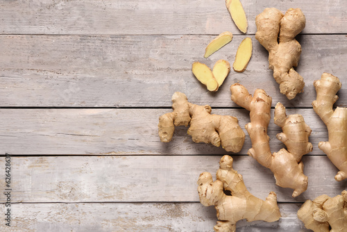 Fresh ginger roots on grey wooden background