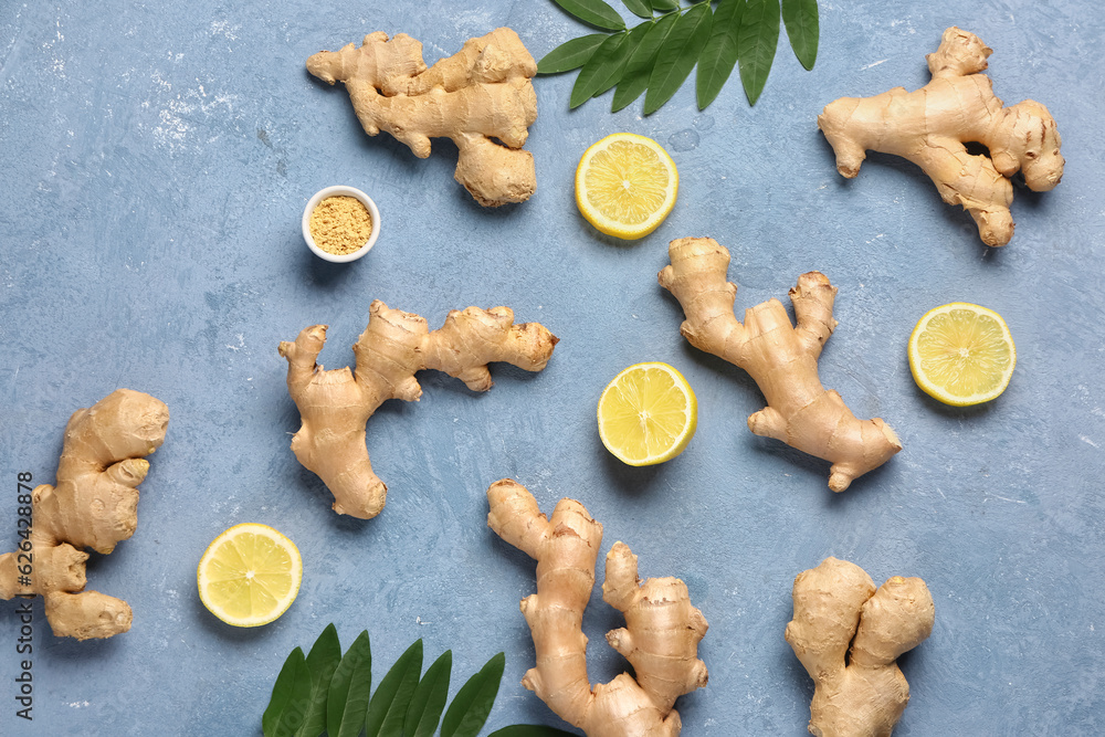 Fresh ginger roots with slices of lemon and leaves on blue background Fresh ginger roots with slices of lemon and leaves on blue background