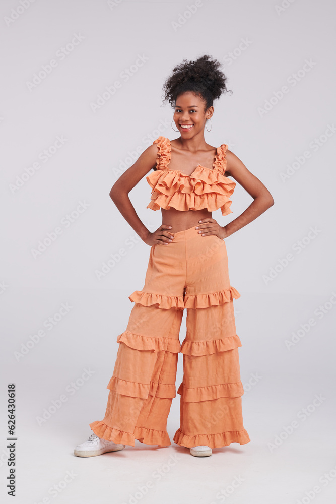 Φωτογραφία A fierce fashionista, a Thai American black woman poses confidently in an orange dress during this studio fashion shoot