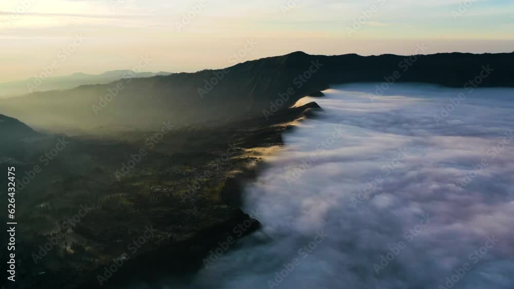 Aerial hyperlapse of fog moving in a valley, sunrise in Tengger, Java, Indonesia Aerial hyperlapse of fog moving in a valley, sunrise in Tengger, Java, Indonesia