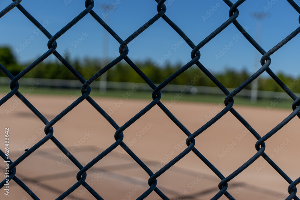 Wire metal fence with baseball field diamond in background. Taken in Toronto, Canada. Wire metal fence with baseball field diamond in background. Taken in Toronto, Canada.