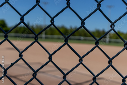 Wire metal fence with baseball field diamond in background. Taken in Toronto, Canada.