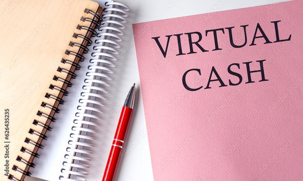 VIRTUAL CASH word on the pink paper with office tools on white background VIRTUAL CASH word on the pink paper with office tools on white background