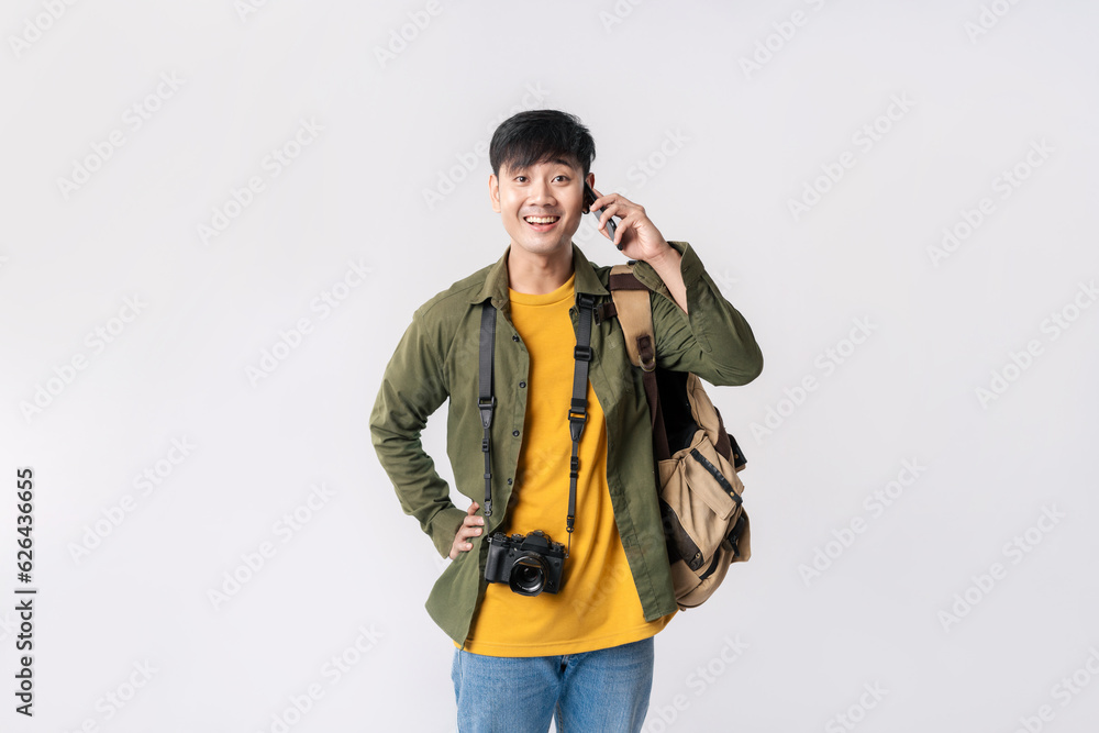 Fashion Asian man backpacker in a casual outfit, Using call phone and looking at camera on isolated white background. Asian man traveller in studio shot. Fashion Asian man backpacker in a casual outfit, Using call phone and looking at camera on isolated white background. Asian man traveller in studio shot.
