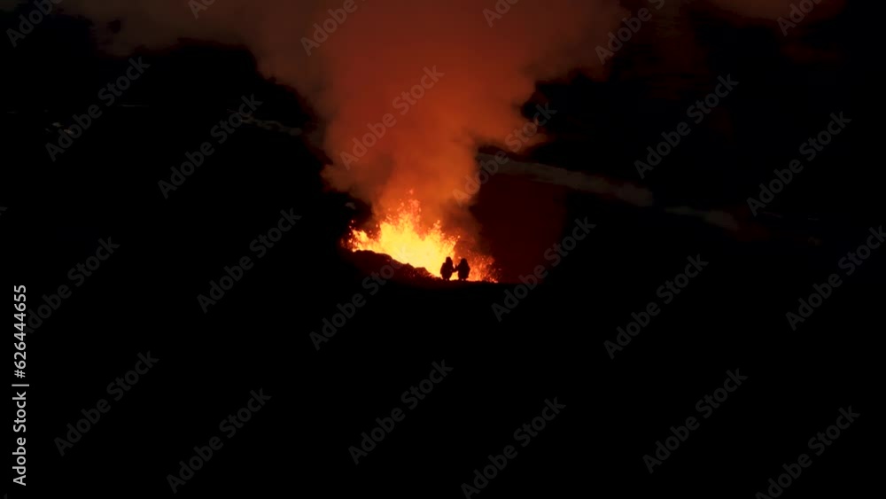 People standing on ridge at night with 2023 volcano eruption in Iceland People standing on ridge at night with 2023 volcano eruption in Iceland