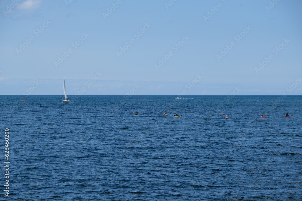 
sailboat and kayaks on the big lake