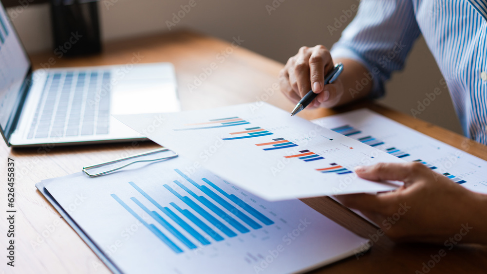 Close up hands of businessman is reading financial document and analysis about strategy of business Close up hands of businessman is reading financial document and analysis about strategy of business