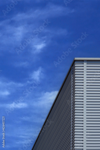Corner of an Industrial Building under blue sky with some clouds