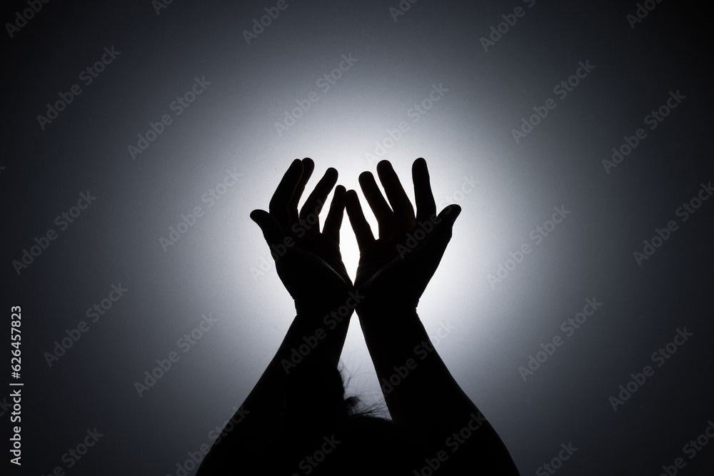 Silhouette photo, A young woman prayed for God's blessings with the power and holiness of God on white background. God and Spiritual Concepts.