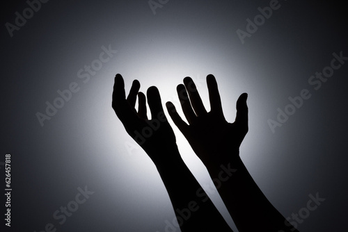 Silhouette photo, A young woman prayed for God's blessings with the power and holiness of God on white background. God and Spiritual Concepts.