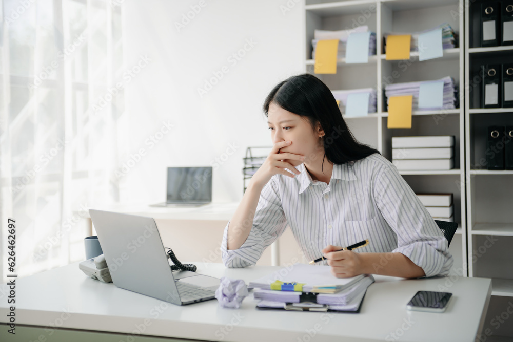 Woman who is tired and overthinking from working with tablet and laptop at modern office. Woman who is tired and overthinking from working with tablet and laptop at modern office.