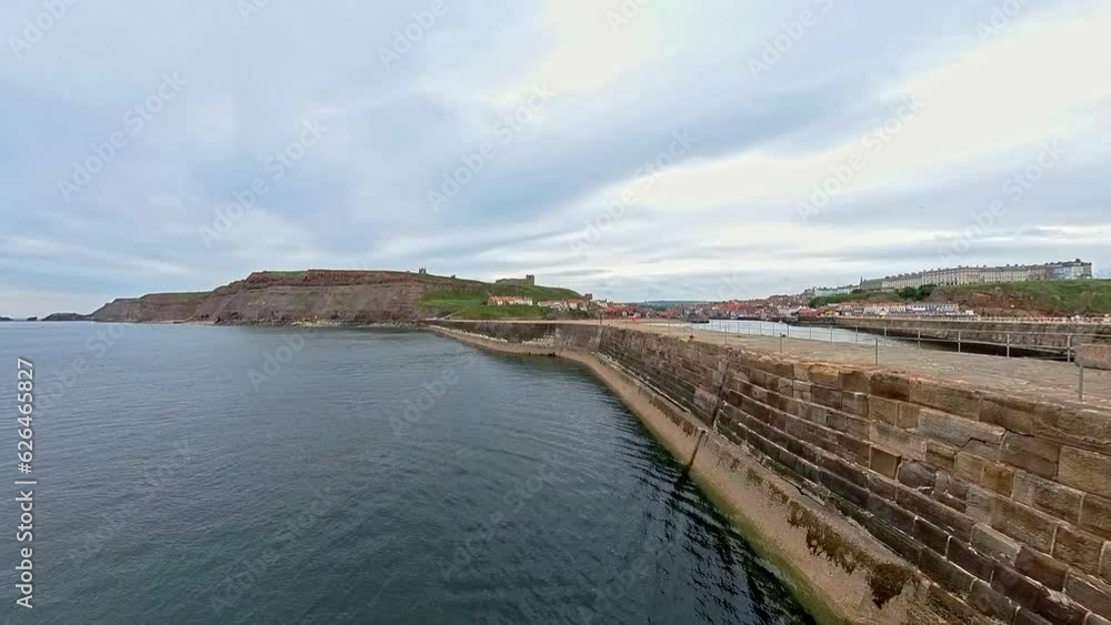 Whitby, North Yorkshire, UK – June 30 2023. The outer harbour wall and North Sea in Whitby on the North Yorkshire coast Whitby, North Yorkshire, UK – June 30 2023. The outer harbour wall and North Sea in Whitby on the North Yorkshire coast