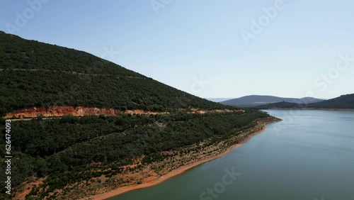 Road driving through the mountain next to a lake of calm waters, Ciudad Real, Spain, photo