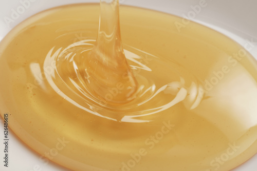 Closeup shot of organic honey pouring in bowl