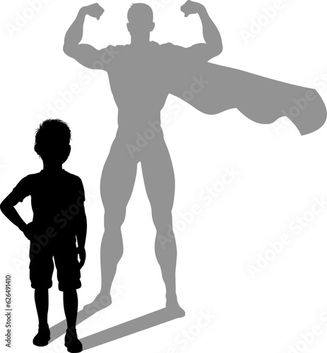 A superhero child or kid boy revealed by his shadow silhouette as a super hero in a cape.