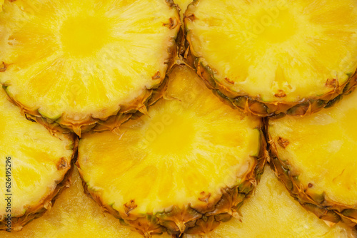 Pineapple juicy yellow slices as a background.