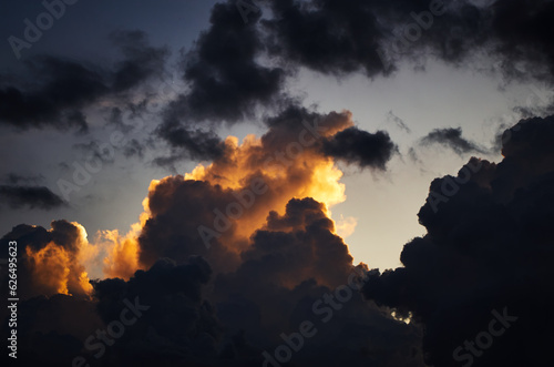 A dark cloud with a sunset in the clouds