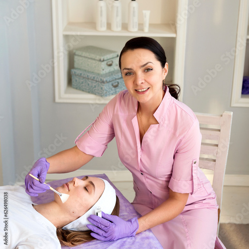 Beautiful young woman having a facial cleansing procedure in a beauty salon