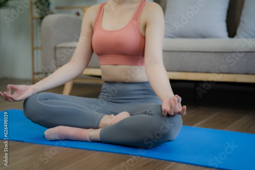 Young woman asian practicing breathing exercise at house.