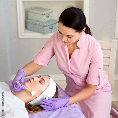 face mask procedure in a beauty salon. Woman getting cosmetology treatment