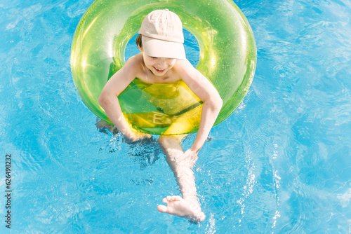 Little boy has a fun with pink ball on swimming pool. © Татьяна Максимова