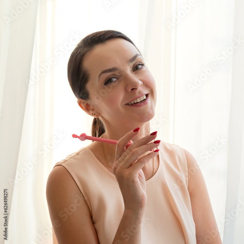 Portrait of a beautiful young woman with makeup pen in her hand
