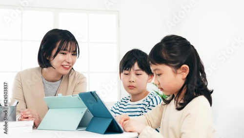 タブレットで勉強する子供たちと教える女性 photo