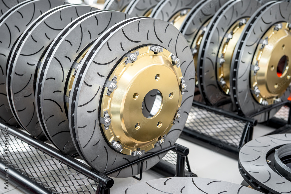 Car mechanic or serviceman disassembly and checking a disc brake and asbestos brake pads for fix and repair problem at car garage or repair shop Car mechanic or serviceman disassembly and checking a disc brake and asbestos brake pads for fix and repair problem at car garage or repair shop
