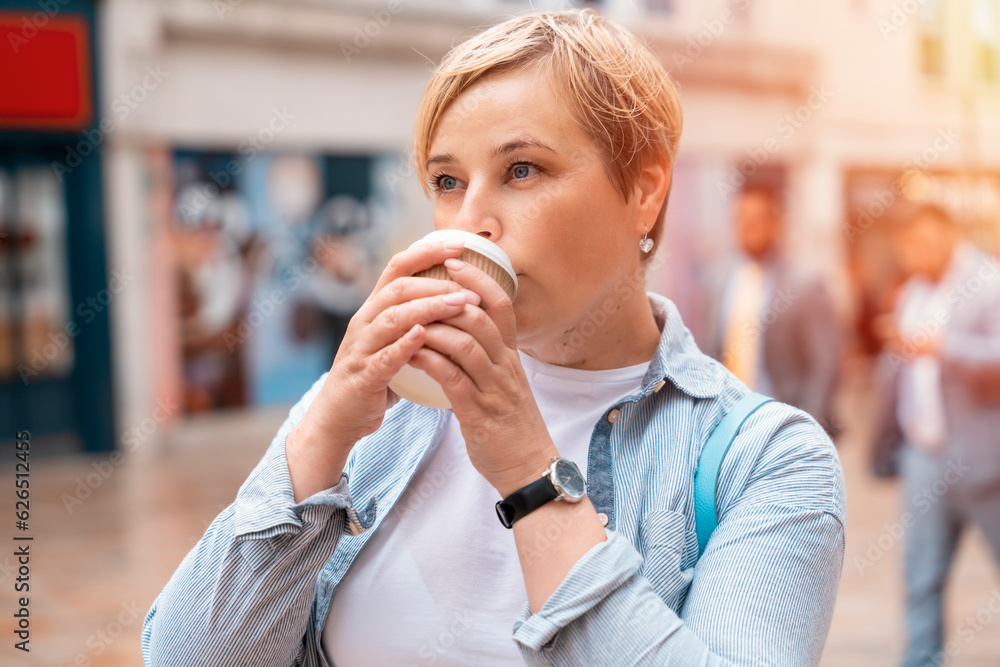 a happy woman in blue shirt with backpack with coffee under a walking around a modern city a happy woman in blue shirt with backpack with coffee under a walking around a modern city