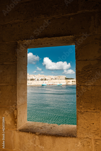 view through the window of an old fortress on the old town and the harbor 
