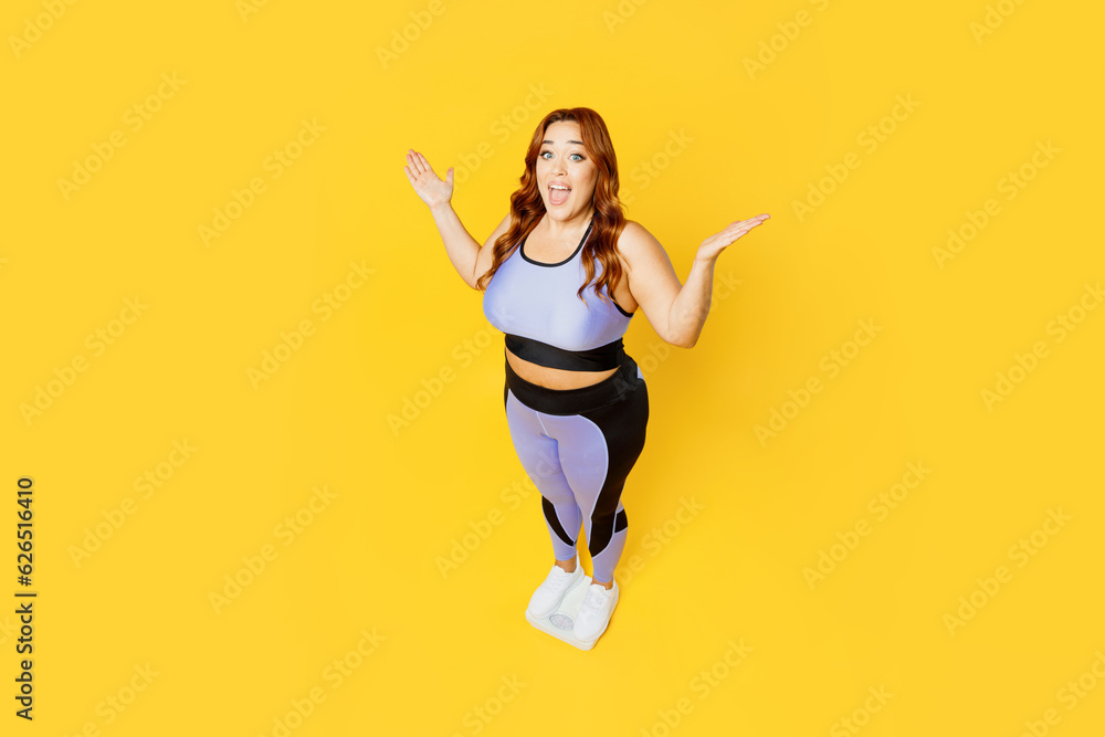 Full body top view from above happy young chubby plus size big fat fit woman wears blue top warm up training stand on scales isolated on plain yellow background studio home gym. Workout sport concept.