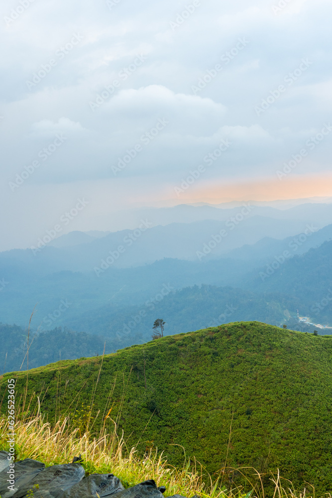 Obraz premium The breathtaking view in Kanchanaburi, Thailand, as seen from the point of view of a tourist, being surrounded by mountains and a golden sky in the background.