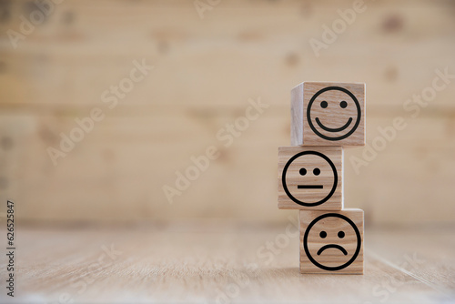 happy sad and neutral faces on wooden cubes use for positivity for the work place and bussiness. Positive mindset conception