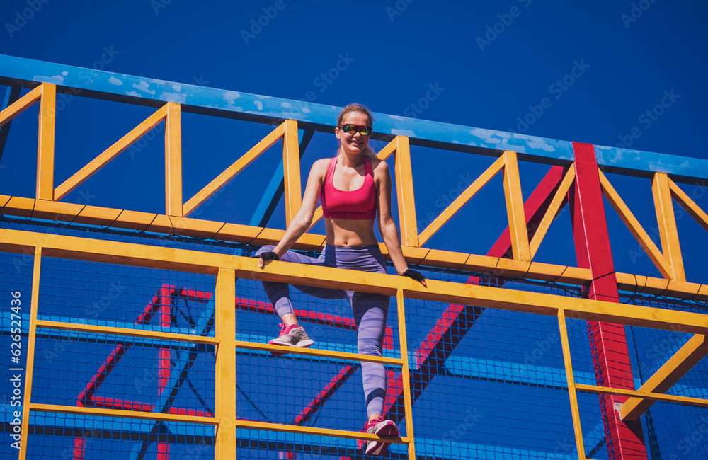 Athletic young woman working out and climbing at the training camp.