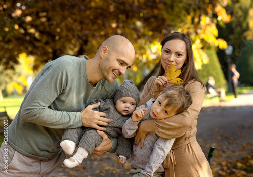 A family with small children walking in the park and playing, autumn