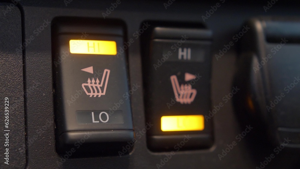 Fototapeta premium Heated Car Seat Switches Being Toggled to Control Seat Warmers