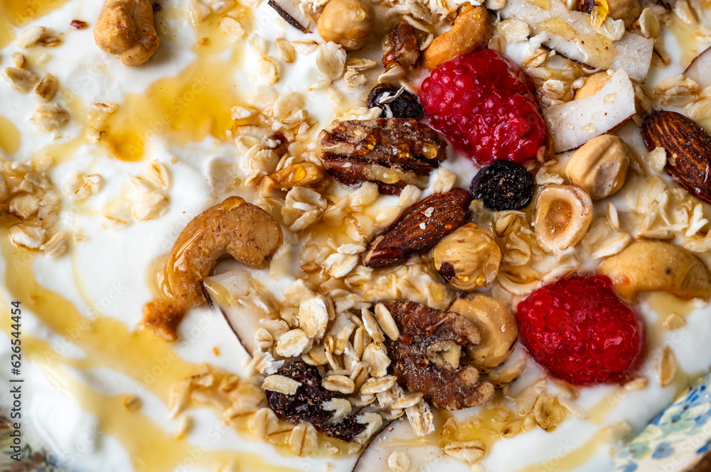 Detail of plate with yoghurt with granola , raspberry and honey. Detail of plate with yoghurt with granola , raspberry and honey.